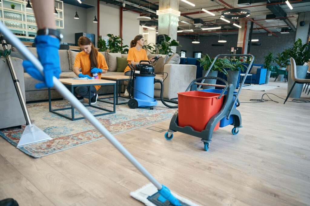 Cleaning in the coworking area, workers use a vacuum cleaner